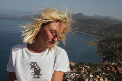 Young woman standing against seascape