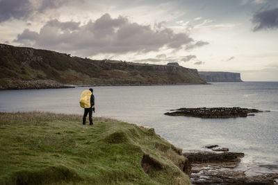 Rear view of people looking at sea against sky