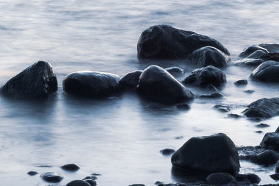 Rocks in sea against sky