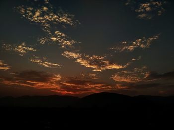 Low angle view of silhouette mountain against dramatic sky