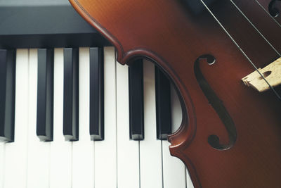 High angle view of violin over piano keys