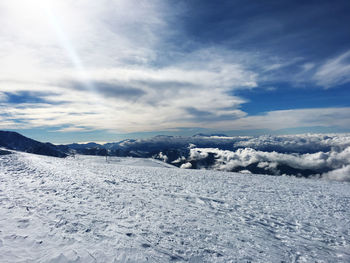 Snow covered landscape against sky