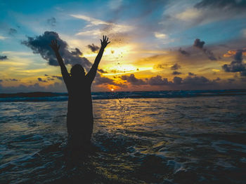 Silhouette man on beach against sky during sunset