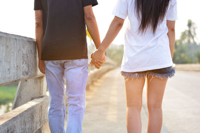 Rear view of couple holding hands