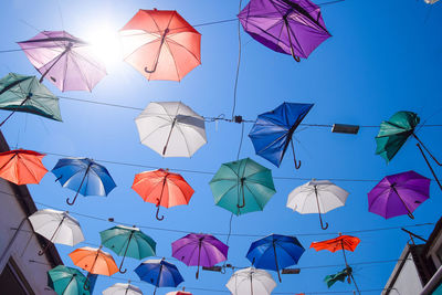 Low angle view of umbrellas hanging against sky