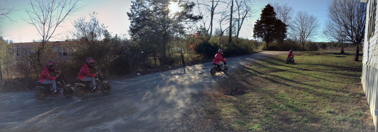 PEOPLE RIDING MOTORCYCLE ON ROAD AGAINST SKY