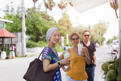 Portrait of smiling friends standing outdoors