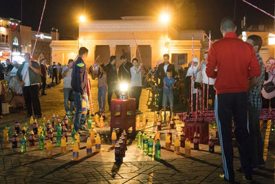 People at illuminated market at night