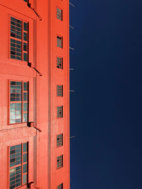 Low angle view of orange building against clear sky