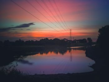 Scenic view of lake against sky at sunset