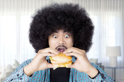 Young man eating food while sitting at home