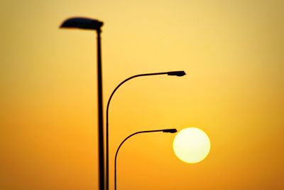 Street lights against clear sky during sunset