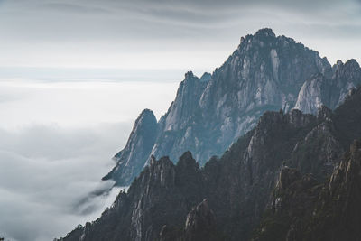 Scenic view of mountains against cloudy sky