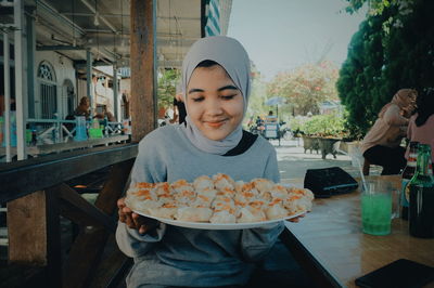 Portrait of smiling woman sitting on restaurant table