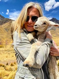 Portrait of a smiling young woman wearing sunglasses on landscape