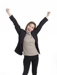 Portrait of smiling young woman standing against white background