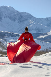 Rear view of woman sitting on mountain
