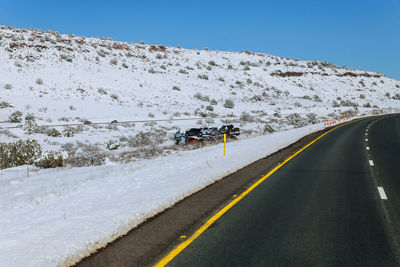 Road by mountain against clear sky