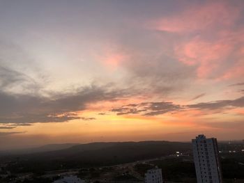 View of cityscape against cloudy sky during sunset