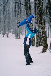 Full length of woman skiing on snow covered field