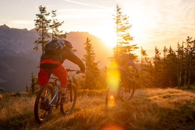 Bicycles parked on field against sky during sunset