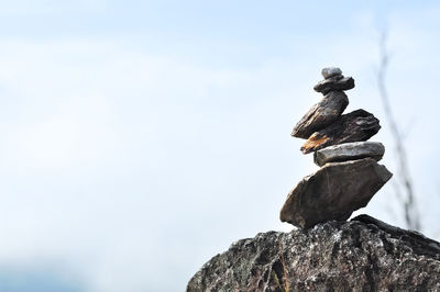 Low angle view of stack of rock against sky