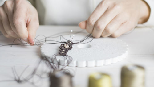 Close-up of woman working with thread on table