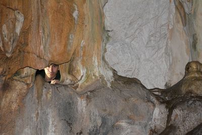 Portrait of woman lying on rock