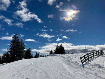 Scenic view of snow covered field against sky