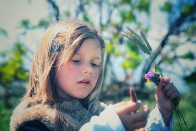 Girl holding flower at park