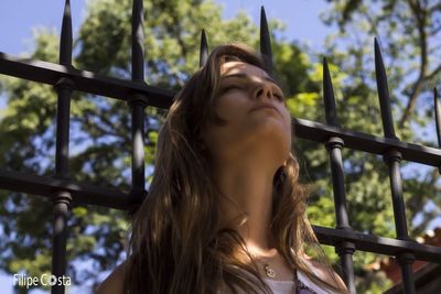 Young woman against trees