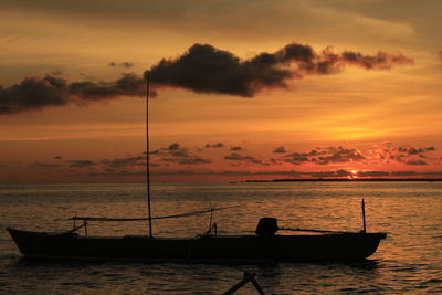 Silhouette boat in sea against sky during sunset