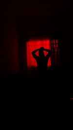 Silhouette man standing in red stage