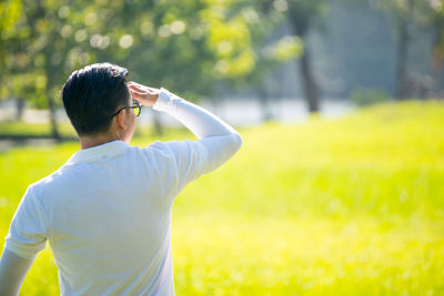 Rear view of mid adult man standing at golf course