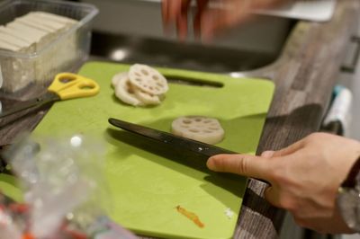 Cropped hands preparing food in kitchen