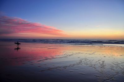 Scenic view of beach against sky during sunset