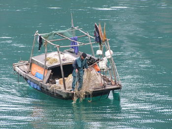 Fisherman sailing on boat in river