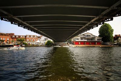 Bridge over river in city against sky