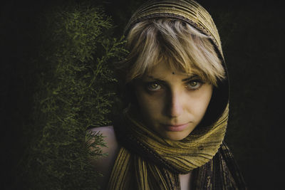 Close-up portrait of young woman against gray background