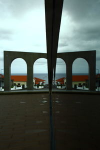 Bridge over river in city against sky