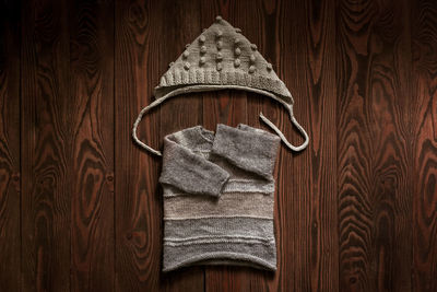 Children's wardrobe, knitted blouses and hats on a wooden background, the concept of autumn 
