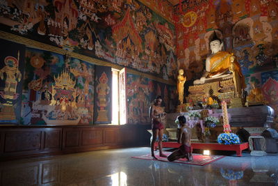 Shirtless men praying in buddhist temple