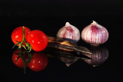 Close-up of fruits on table against black background