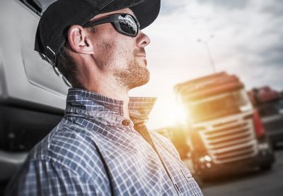 Side view of man wearing cap and sunglasses while looking away