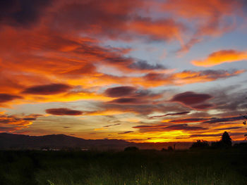 Scenic view of dramatic sky over silhouette landscape