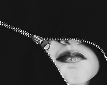 Close-up portrait of a serious young woman over black background