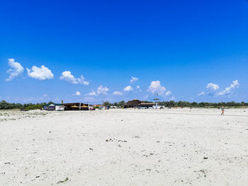 Scenic view of beach against blue sky