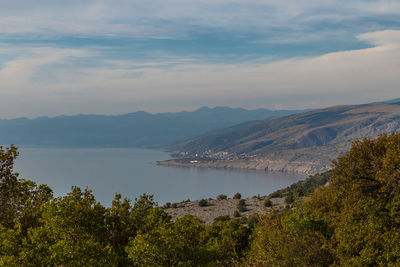 Scenic view of sea and mountains against sky