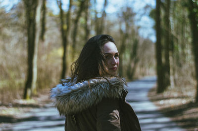 Young woman standing in forest during winter