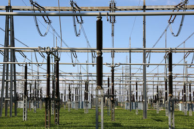 Electricity pylon on field against sky